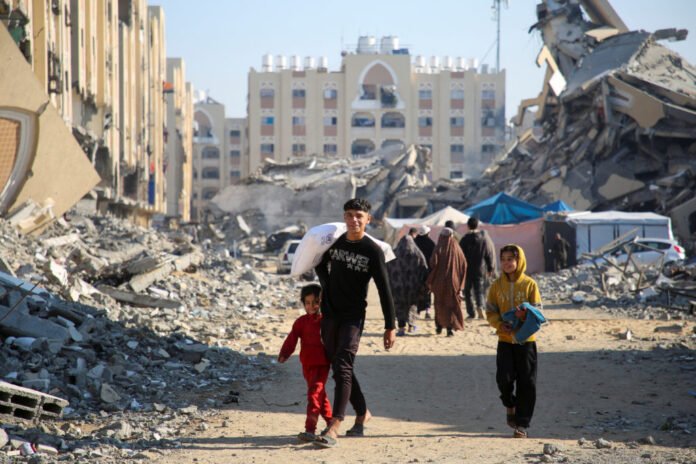 Palestinians receive bags of flour distributed by UNRWA in Khan Younis in the southern Gaza Strip